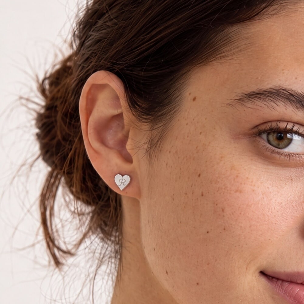 Modelo luciendo pendientes en forma de corazón, resaltando un estilo delicado y elegante