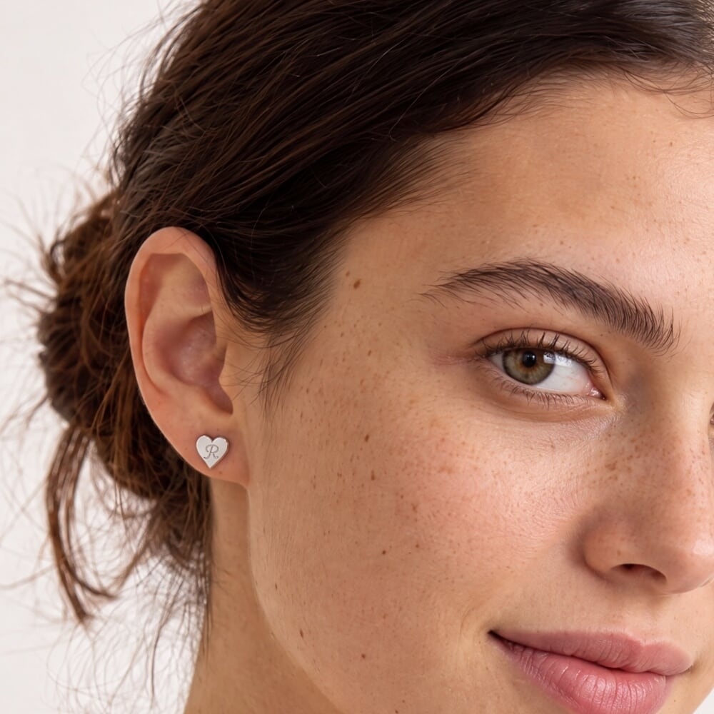 Modelo luciendo pendientes en forma de corazón, destacando un estilo encantador y delicado