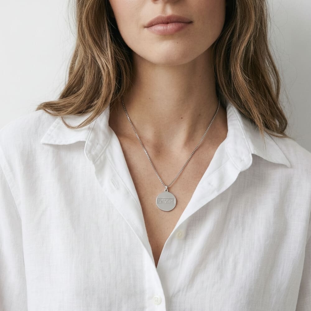 Model showcasing Braille Disc Necklace with a casual white blouse