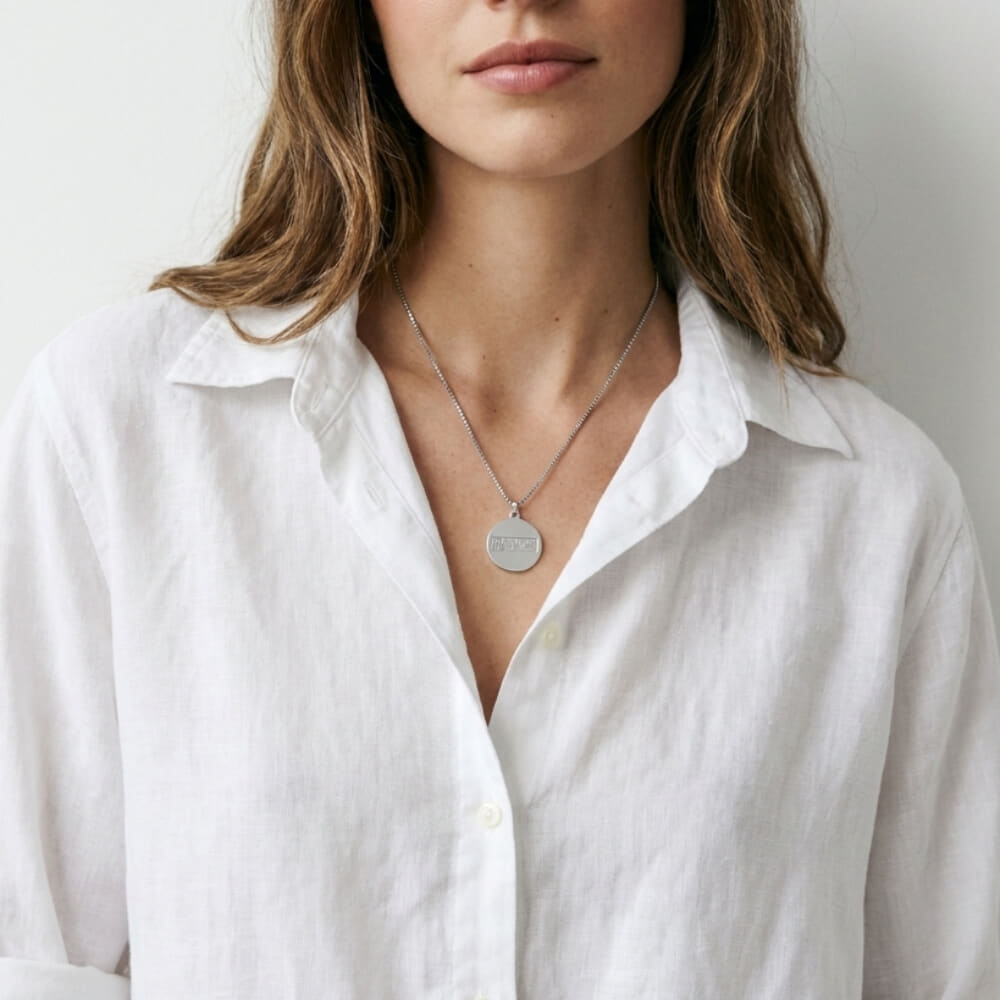 Woman styled in Braille Disc Necklace paired with a casual white shirt
