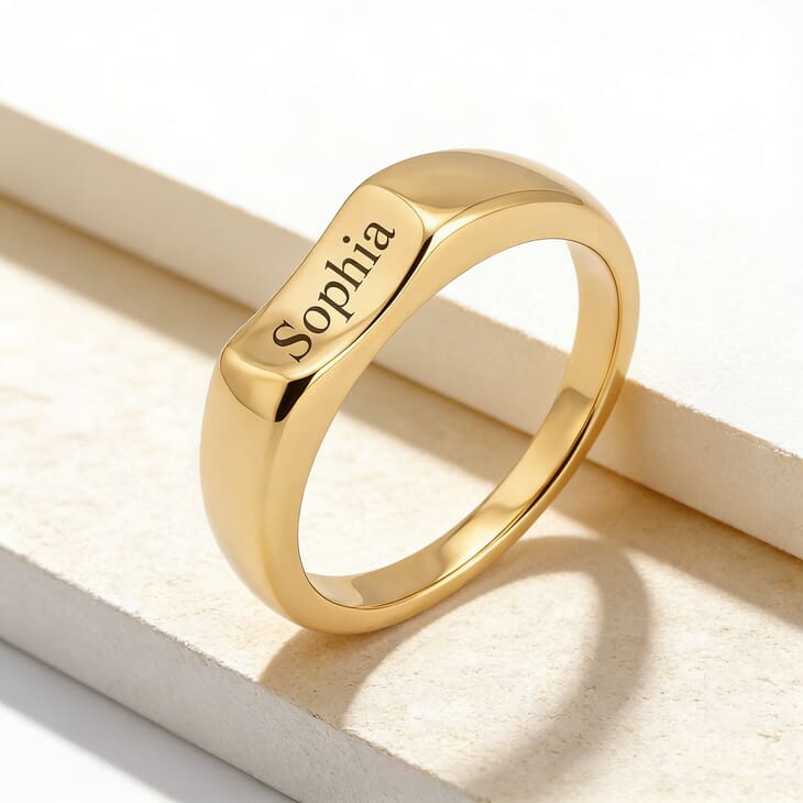 Model stylishly presenting a personalized curved signet ring featuring the name Sophia on a soft backdrop