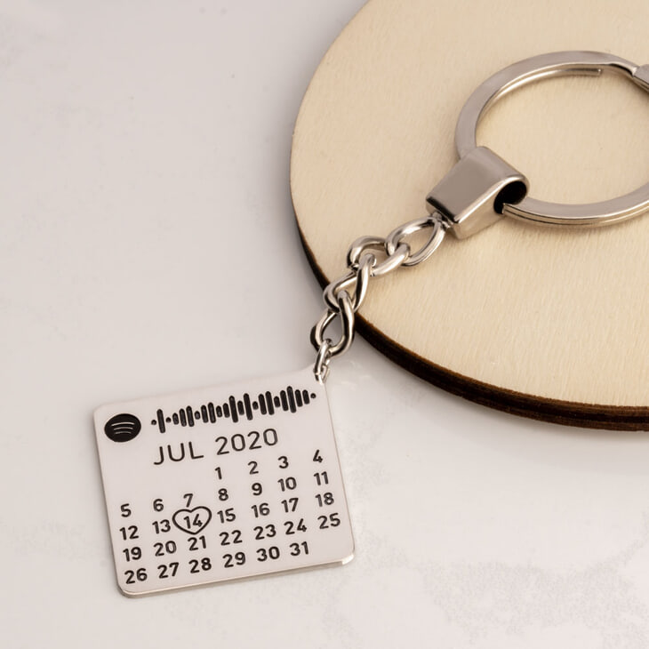A silver Spotify Date Custom Keychain highlights a personalized date and song code.