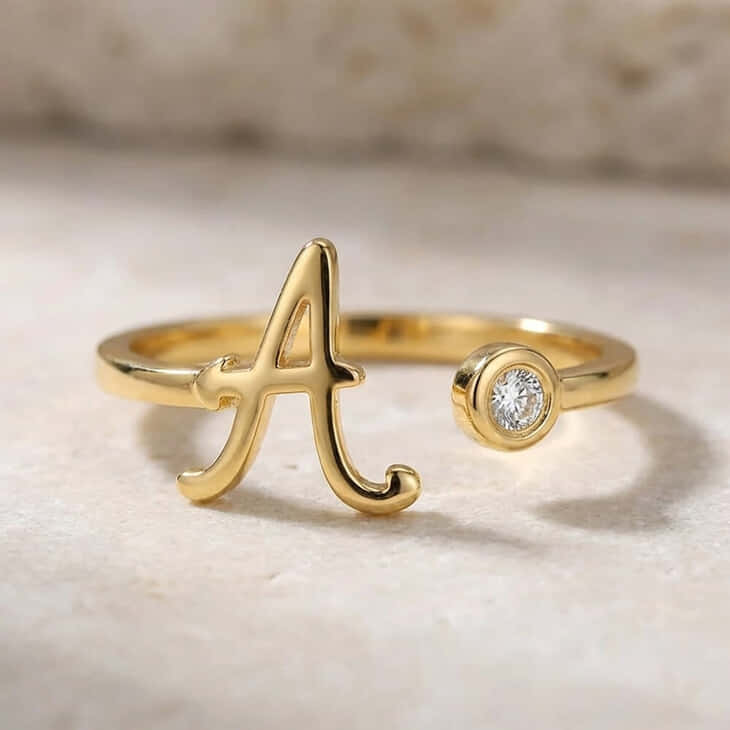 Cursive initial ring in gold with an elegant birthstone detail