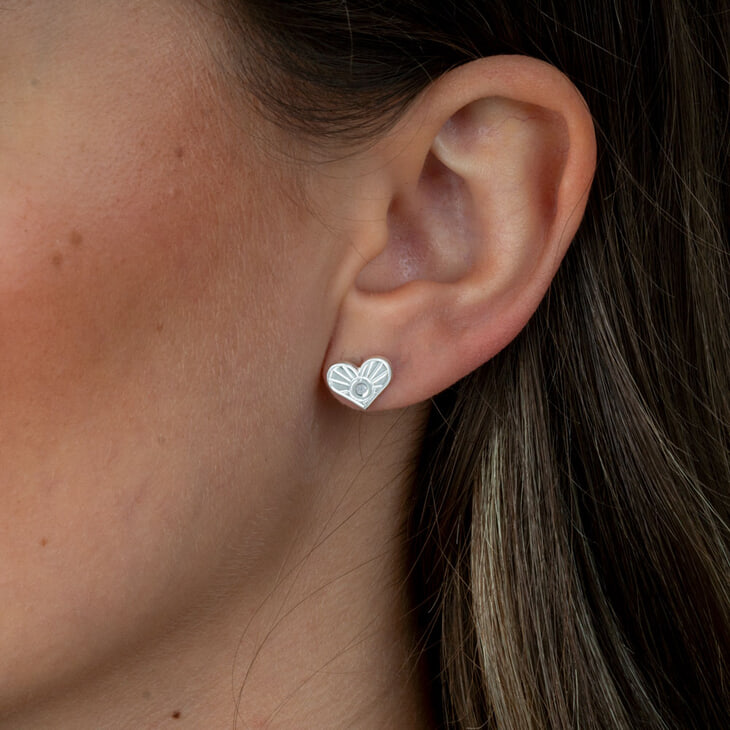 Modèle présentant des boucles d'oreilles en forme de cœur en diamant, élégance en avant