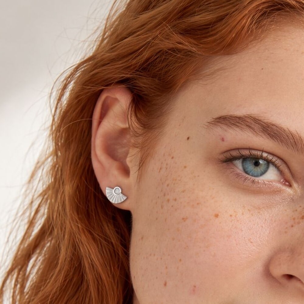 Modèle arborant des boucles d'oreilles en diamant au design élégant et moderne.