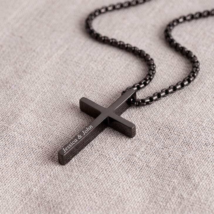 Gros plan sur le collier croix noire gravée avec texte personnalisé sur le pendentif