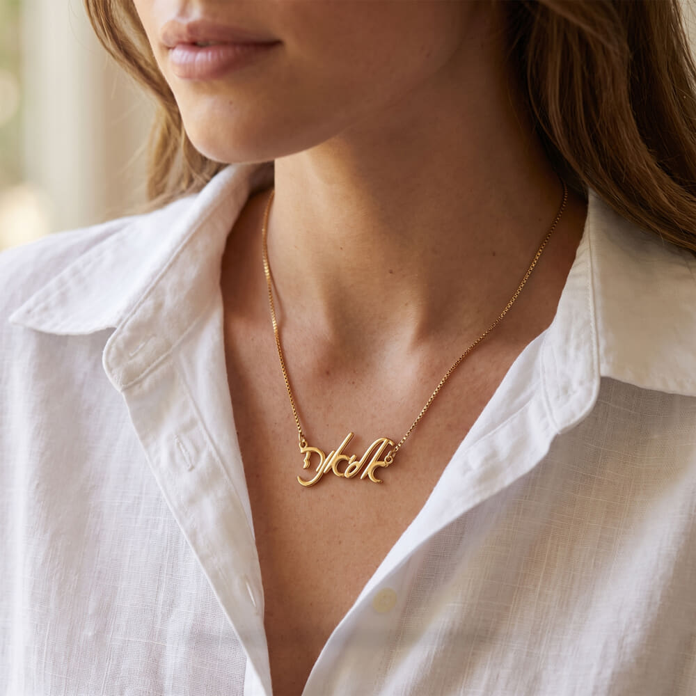 Model wearing the Elegant Hebrew Script Name Necklace with a stylish white shirt.
