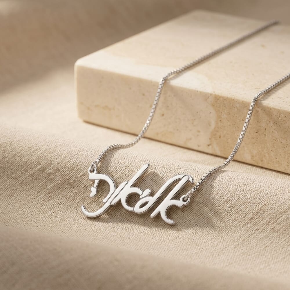 Model wears the Elegant Hebrew Script Name Necklace, styled with a soft beige background.