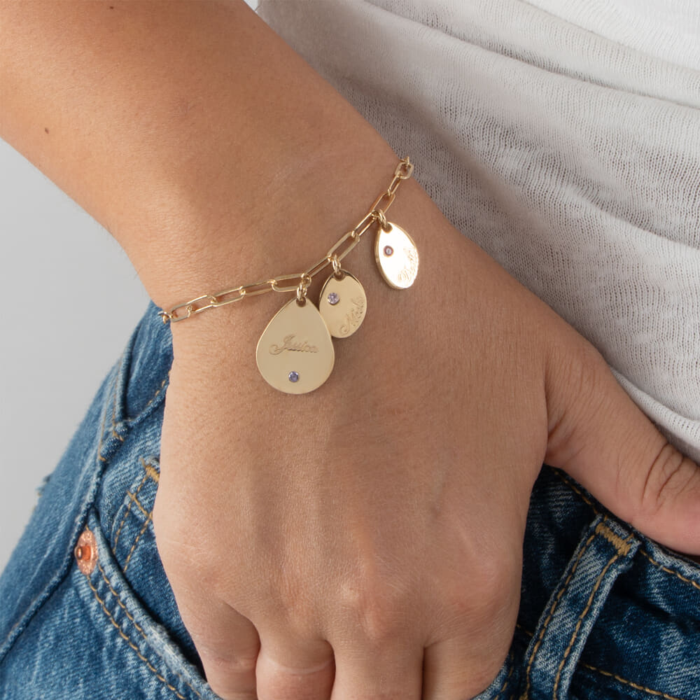 Gold personalized name and birthstone drop charm bracelet worn on wrist