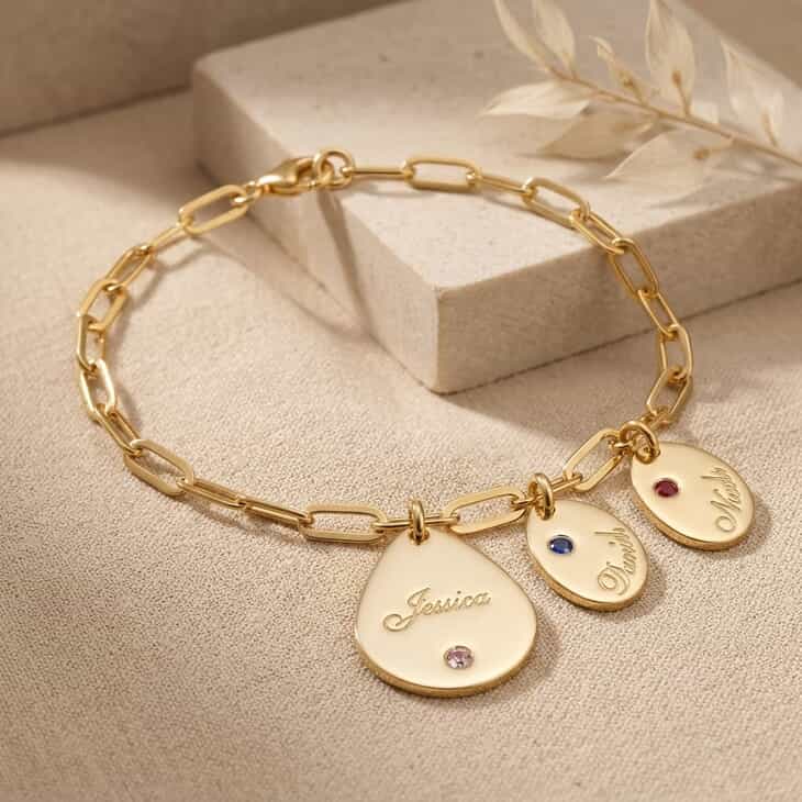 Gold name charm bracelet featuring personalized names and birthstones
