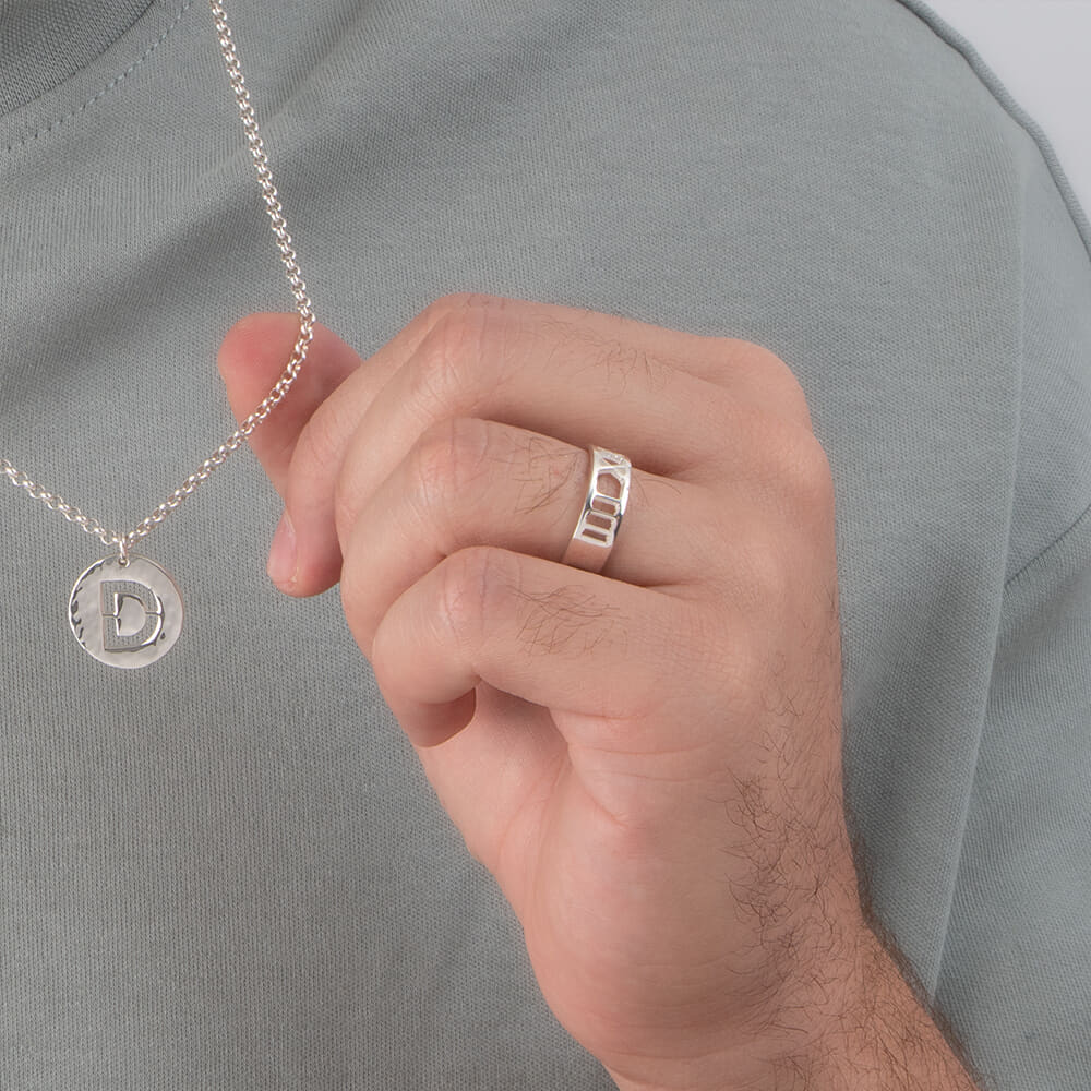 Model highlighting a Custom Men's Roman Numeral Ring while casually holding a necklace.