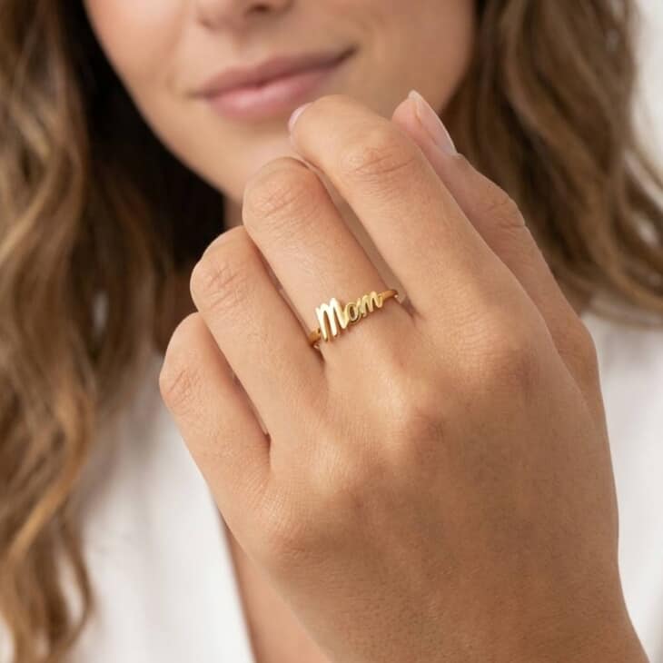 Anillo Dainty Mom en acabado dorado, lucido en una mano