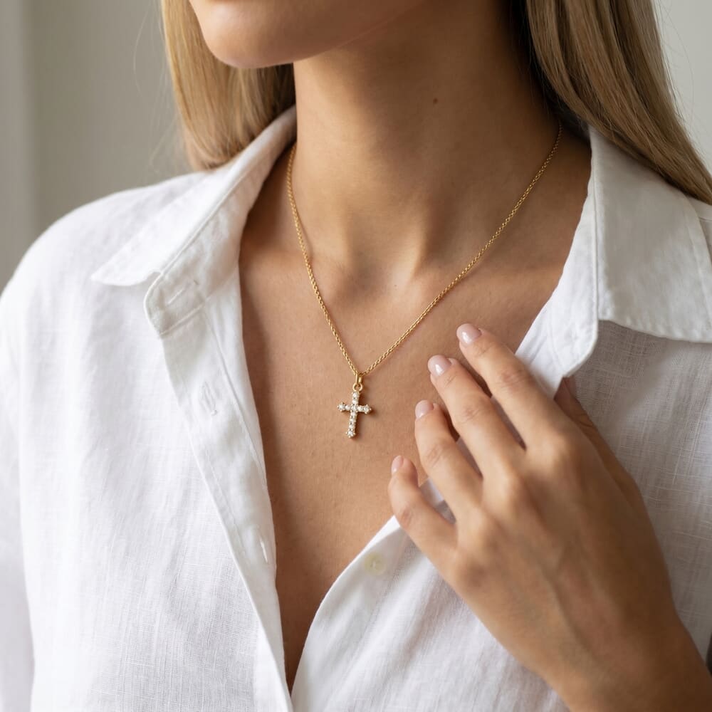 Model elegantly showcases the Small Inlaid Cross pendant with a stylish white shirt