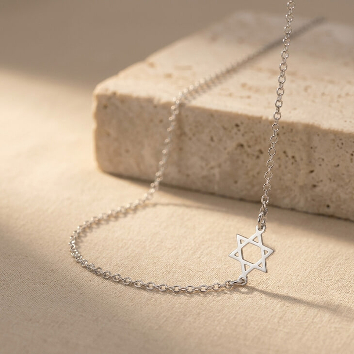 Silver Sideways Star of David Necklace showcased against a soft, textured backdrop