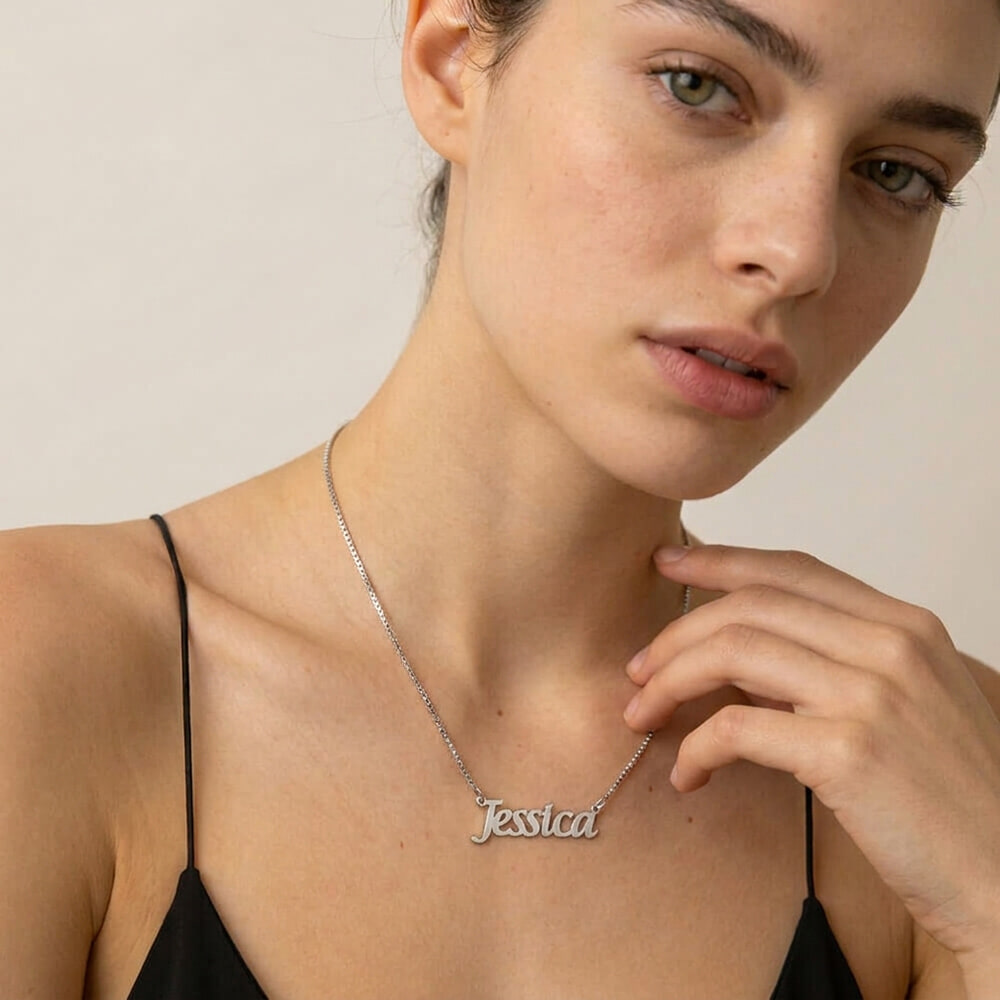 Close-up of a model wearing The Everyday Name Necklace in elegant script style.