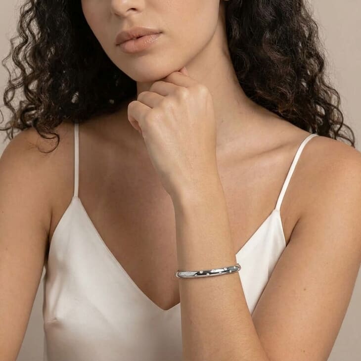 Mujer exhibiendo el brazalete abierto Celestial Star, resaltando su diseño elegante sobre un fondo claro
