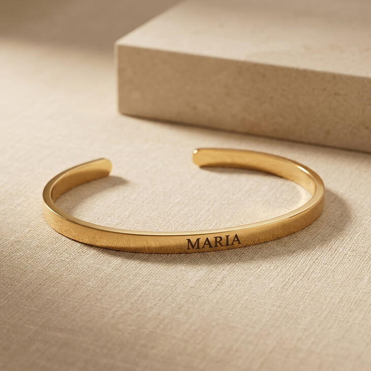 Personalized Thin Open Bangle Bracelet engraved with 'MARIA' on a textured background