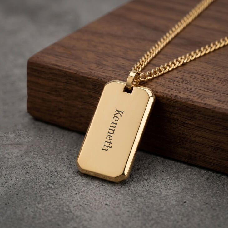 Collar dog tag grabado en oro para hombres sobre superficie de madera