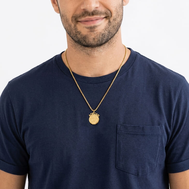 Person displaying a Personalized Soccer Ball Name Necklace with a relaxed look in a blue shirt