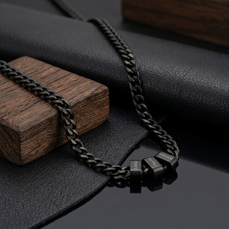 Detailed view of a black dad necklace with engraved names on dark surface