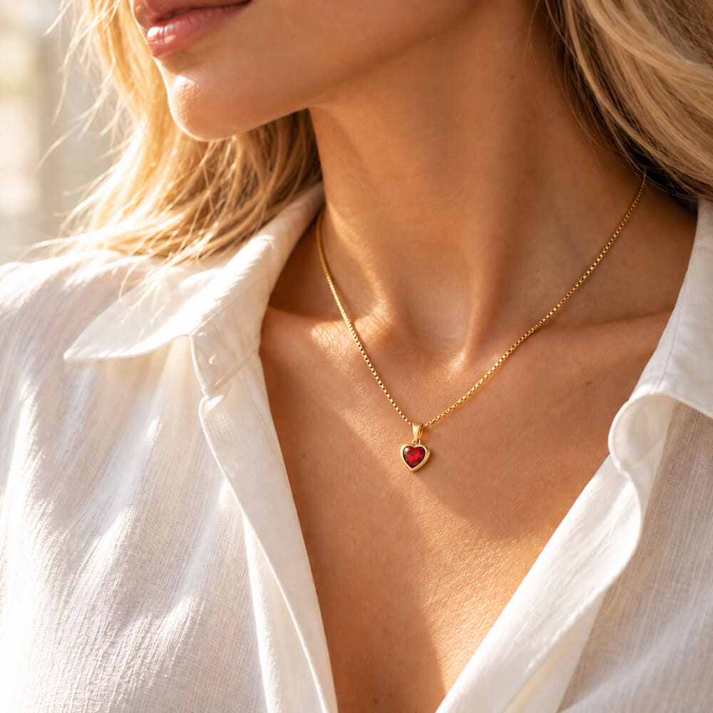 Lifestyle shot of a woman with a heart pendant necklace against a soft backdrop